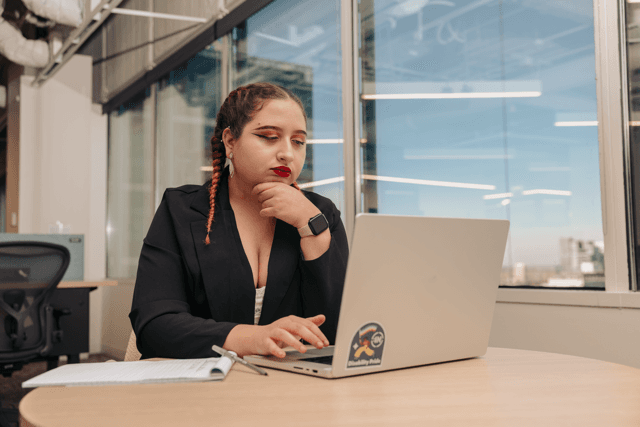 A person working on a laptop in an office environment.